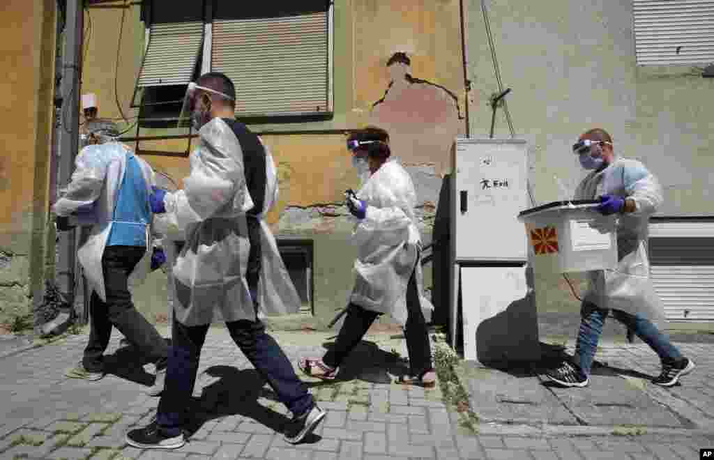 Members of a special election team with a ballot box and voting materials make their way to voters who have tested positive for COVID-19 or are in self-isolation, in Skopje, North Macedonia.