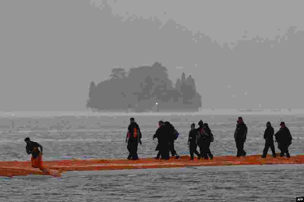 Para pekerja menyelesaikan konstruksi "Dermaga Mengambang" di Danau Iseo, Italia utara.