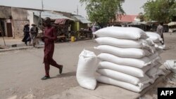 FILE - People walk on a street in the town of Damasak, northeast Nigeria, April, 25 2017. The U.N. has suspended aid operations in the town after attacks targeting aid workers and humanitarian agencies in April 2021.