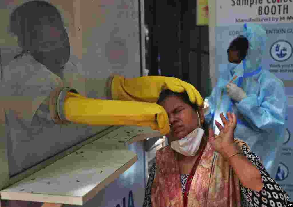 A health worker collects a nasal swab sample to test for COVID-19 in Hyderabad, India.