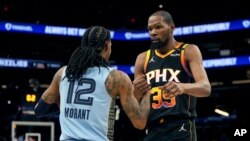 El base de los Memphis Grizzlies, Ja Morant (12), y el delantero de los Phoenix Suns, Kevin Durant (35), se dan la mano después de un partido de baloncesto de la NBA, el martes 11 de febrero de 2025, en Phoenix. AP/Rick Scuteri