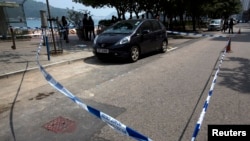 The car of former Ming Pao chief editor Kevin Lau is surrounded by a cordon line after he was attacked in Hong Kong, Feb. 26, 2014.