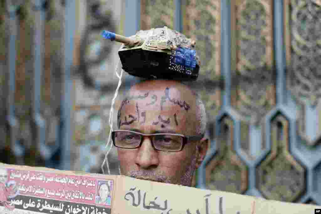 An Egyptian protester with Arabic writing on his forehead that reads, "Muslims and Christians, one hand," attends a demonstration outside the presidential palace, in Cairo, Egypt, Dec. 5, 2012.