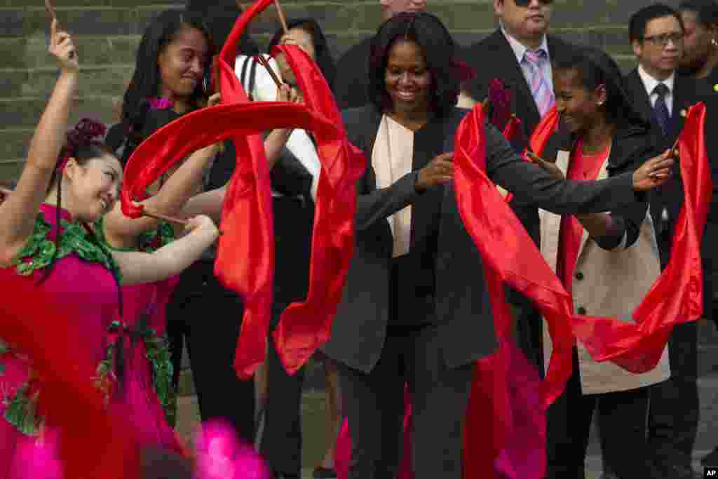 Ibu negara AS Michelle Obama ikut menari bersama para penari China dalam kunjungan ke Tembok Besar China di Beijing bersama kedua puterinya, Malia dan Sasha. 