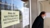 A man leaves a vaccination site with a sign reading "No vaccination with the AstraZeneca vaccine today," in Saint-Jean-de-Luz, southwestern France, March 16, 2021. 