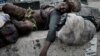 FILE - A homeless woman sleeps under a pedestrian bridge in Port Harcourt, southern Nigeria, Feb. 22, 2019