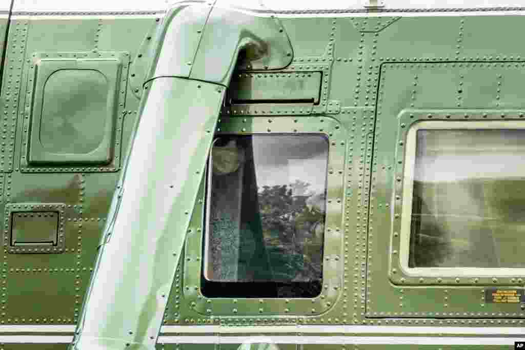 First lady Melania Trump wears a face mask as she sits aboard Marine One with President Donald Trump before they depart from the South Lawn of the White House in Washington for a short trip to Andrews Air Force Base, Md.