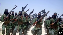 FILE - Al-Shabab fighters march with their weapons during exercises on the outskirts of Mogadishu, Somalia, Feb. 17, 2011. 