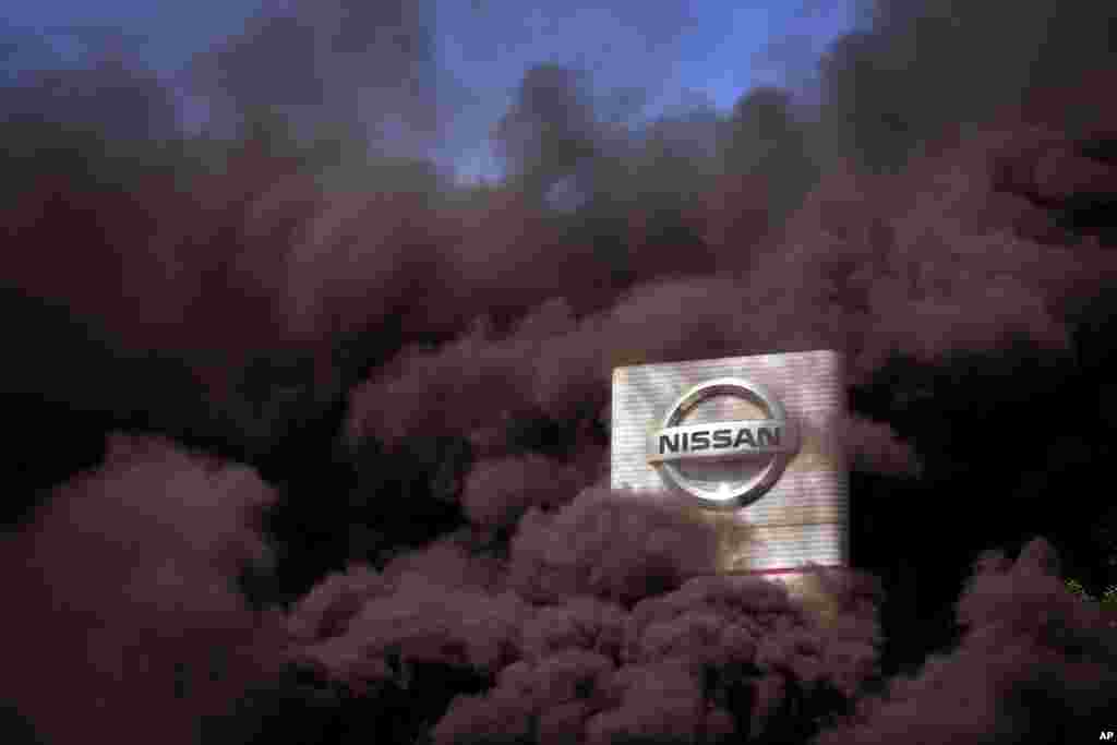 Smoke rises over the Nissan factory as workers burn tires during a protest in Barcelona, Spain. Japanese carmaker Nissan Motor Co. is closing its manufacturing plants in the northeastern Catalonia region, resulting in the loss of some 3,000 direct jobs.