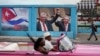 Un automóvil antiguo pasa junto a una imagen del expresidente de Cuba, Raúl Castro, y del presidente y primer secretario del Partido Comunista de Cuba, Miguel Díaz-Canel, junto a un cartel que dice: "Somos continuidad", en La Habana, Cuba, el 17 de abril de 2023.