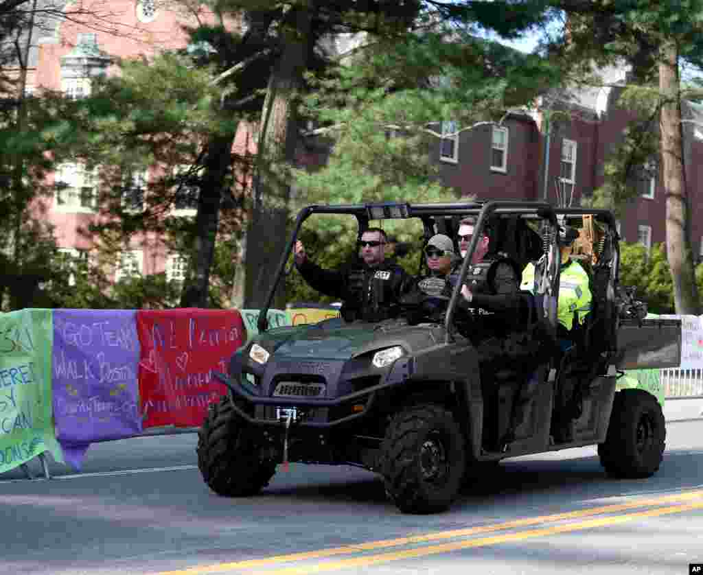 Tim Polisi Negara Bagian Tanggap Khusus berpatroli melewati poster-poster berisi ucapan semangat di Wellesley College sebelum dimulainya Boston Marathon ke-118, Wellesley, Mass., 21 April 2014.