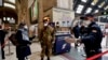 FILE - Police officers and soldiers check passengers leaving from Milan main train station, March 9, 2020. 