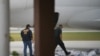 Dos miembros del Servicio de Inmigración y Aduanas de EE. UU. revisan equipajes que subirán a un avión en Brownsville, Texas, el 18 de mayo de 2019.