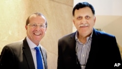 FILE - In this Feb. 17, 2016 file photo, U.N. special envoy for Libya Martin Kobler, left, is greeted by Fayez Serraj, Libyan designated-prime minister and head of the presidential council, in Cairo, Egypt.