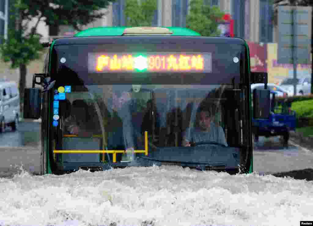 Sebuah bis berusaha melewati jalanan yang banjir di Jiujiang, Jiangxi, China.