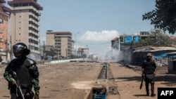 FILE - Police officers in riot gear confront demonstrators (not pictured) during mass protests after preliminary election results were announced in Conakry, Guinea, Oct. 23, 2020. 