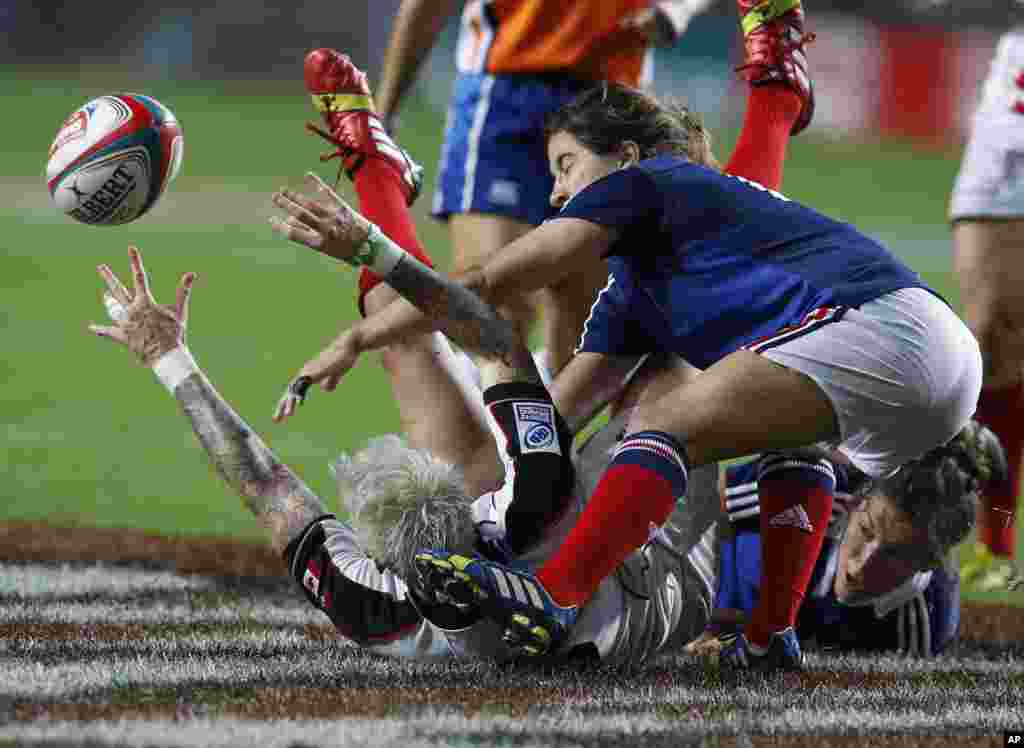 Pemain Kanada Jennifer Kish (kiri) di tanah, dihadang oleh pemain Perancis Jade Le Pesq (kanan) dalam pertandingan final Piala Invitational Putri di Turnamen Rugby Hong Kong Sevens. 