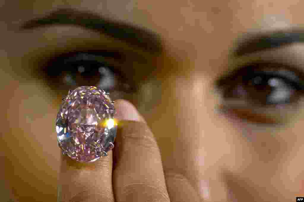 A model shows a 59.6-carat pink diamond that will be auctioned by Sotheby's in the Swiss city of Geneva in November at a record asking price of $60 million (49 million euros).