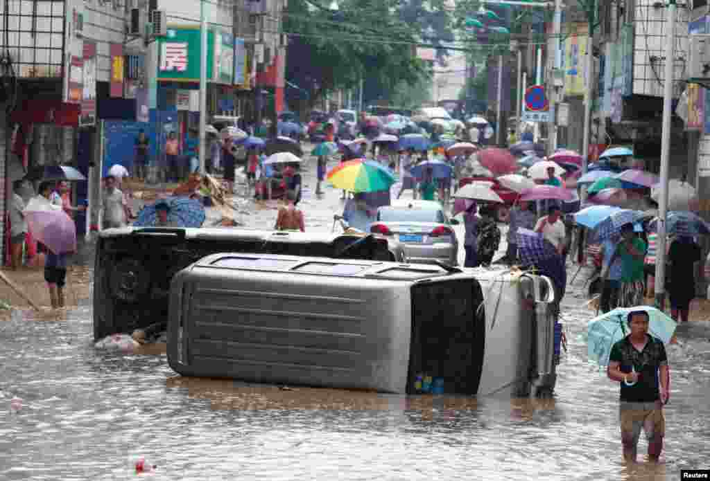 Mobil-mobil bergelimpangan ketika banjir melanda jalanan di Liuzhou, Guangxi Zhuang, China.