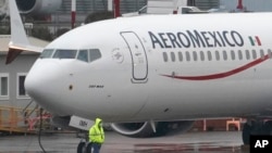 ARCHIVO - Un trabajador con una máscara pasa junto a un Boeing 737 Max 9 construido para Aeroméxico mientras lo preparan para un vuelo desde el Aeropuerto Municipal de Renton, en Renton, Washington, el 18 de noviembre de 2020. 