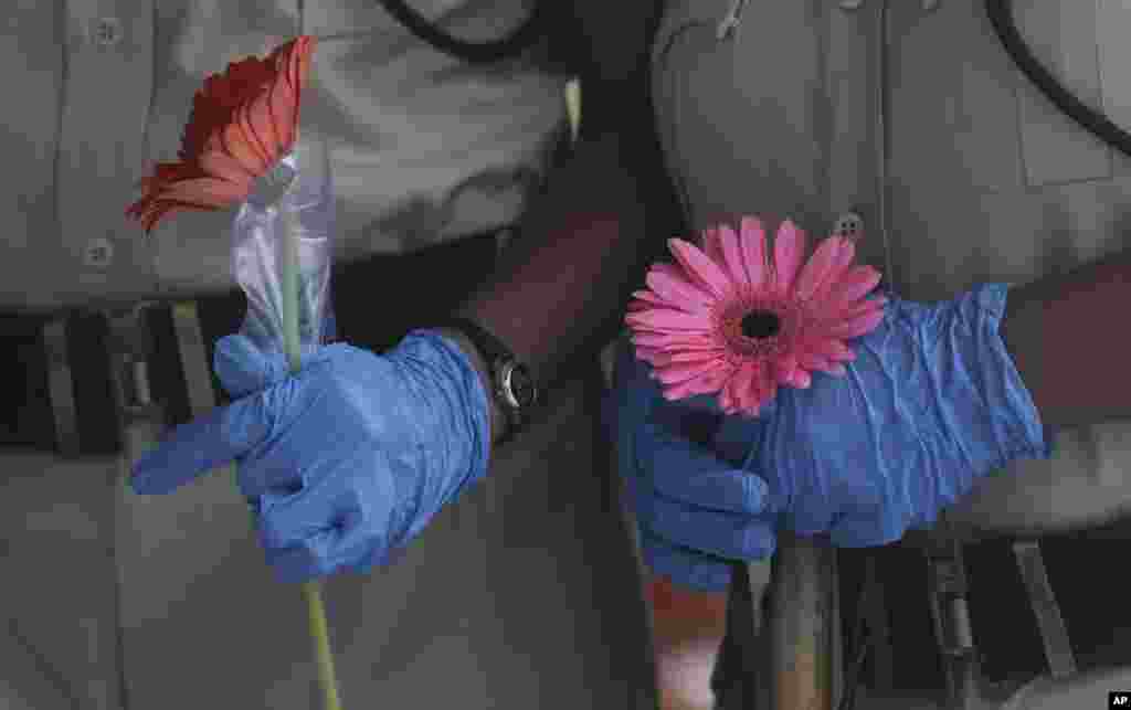 Security officers hold flowers given to them as a gesture of gratitude at the end of a free medical camp in Dharavi, one of Asia's biggest slums, in Mumbai, India.