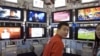 在2006年北京國際廣播電影電視設備展上，一位男士站在一系列電視機前。（資料圖片）