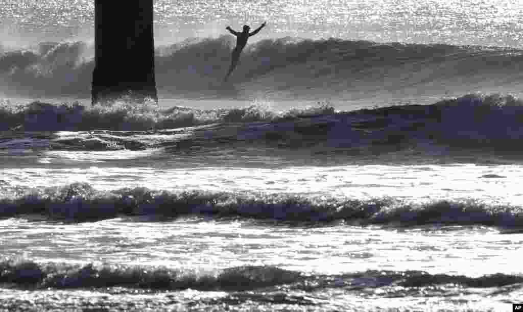 A surfer rides a winter wave at New Brighton Beach in Christchurch, New Zealand.