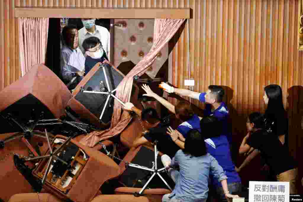 Lawmakers from Taiwan's ruling Democratic Progressive Party (DPP) scuffle with lawmakers from the main opposition Kuomintang (KMT) party, in Taipei, Taiwan.