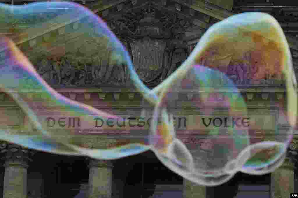 Gelembung sabun mengapung melewati tulisan "Dem Deutschen Volke" (Untuk Rakyat Jerman) pada bangunan gedung 'Reichstag Bundestag' (majelis rendah parlemen Jerman) di Berlin.