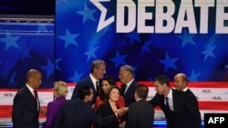 Democratic presidential hopefuls, left to right, Cory Booker, Elizabeth Warren, Julian Castro, Bill de Blasio, Tulsi Gabbard, Amy Klobuchar, Jay Inslee, moderator Chuck Todd, Beto O’Rourke and John Delaney greet each other after the debate. 