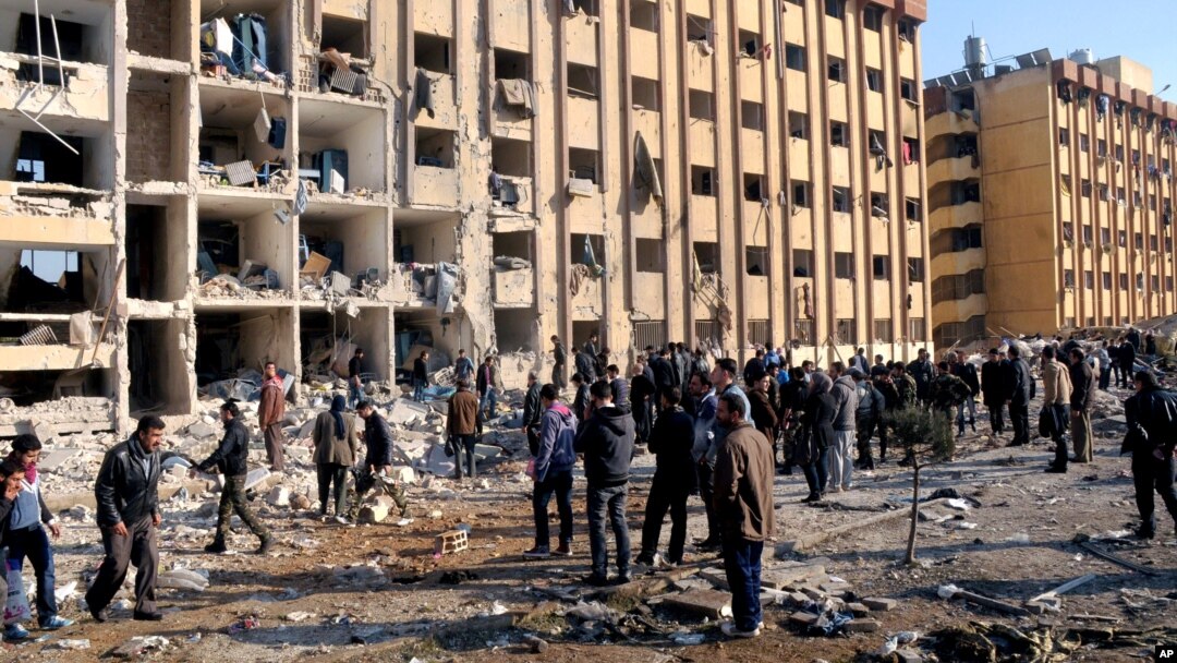 In this photo released by the Syrian official news agency SANA, Syrian people gather at the site after an explosion hit a university in Aleppo, Syria, Jan. 15, 2013.