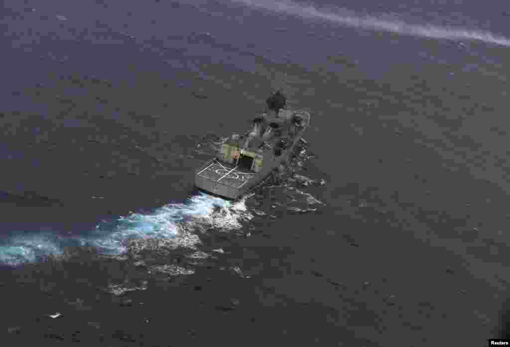 Kapal Angkatan Laut Australia HMAS Perth dipandu menuju posisi oleh pesawat ngkatan Udara Selandia Baru saat terbang di atas Samudera Hindia untuk melanjutkan pencarian pesawat Malaysia Airlines dengan nomor penerbangan MH370 (13/4). (Reuters/Greg Wood)