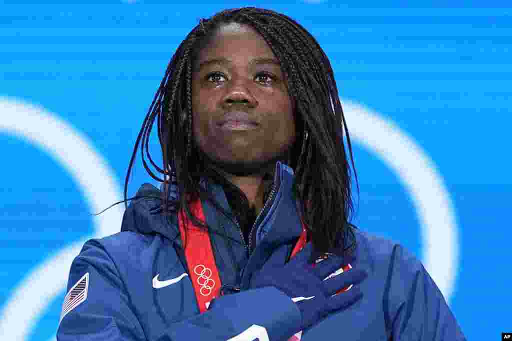 Gold Medalist Erin Jackson of the United States stands for her national anthem during the medal ceremony for the speedskating women's 500-meter race at the 2022 Winter Olympics, Feb. 14, 2022, in Beijing, China.