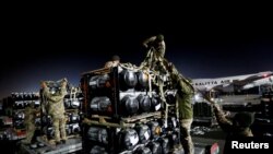 Ukrainian service members unpack Javelin anti-tank missiles, delivered by plane as part of the US military support package for Ukraine, at the Boryspil International Airport outside Kyiv, Ukraine, Feb. 10, 2022. 