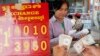 FILE - A currency trader counts Cambodian riels to exchange for U.S. dollars at a money exchange stall in the capital Phnom Penh, Cambodia, Feb. 15, 2008. Cambodia racked up $278 million in U.S. loans under the Lon Nol government in the 1970s.