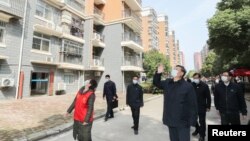 中國國家主席習近平在視察武漢一個居民區時向被隔離的居民招手致意。（2020年3月10日）
