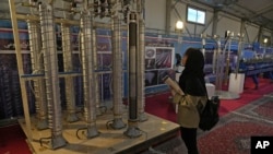 FILE - A student looks at Iran's domestically built centrifuges in an exhibition of the country's nuclear achievements, in Tehran, Iran, Feb. 8, 2023. Iran has increased its supply of uranium that has been enriched to 60% purity, according to IAEA reports seen by news agencies.  