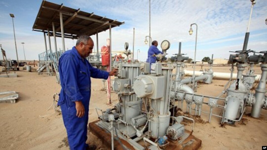 Workers check pipes and valves at Amaal oil field in eastern Libya, October 7, 2011.