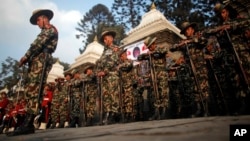 Nepalese army soldiers give a guard of honor during the cremation of Nepalese prime minister Sushil Koirala, on the banks of the Bagmati River in Kathmandu, Nepal.