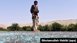 FILE - An Afghan soldier keeps watch during clashes with Islamic State (IS) militants in Kot district of Nangarhar province, Afghanistan.