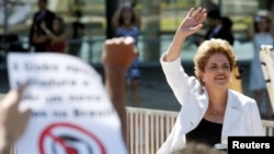 A Presidente suspensa, Dilma Rousseff, acena aos seus apoiantes à saída do Palácio do Planalto em Brasília.