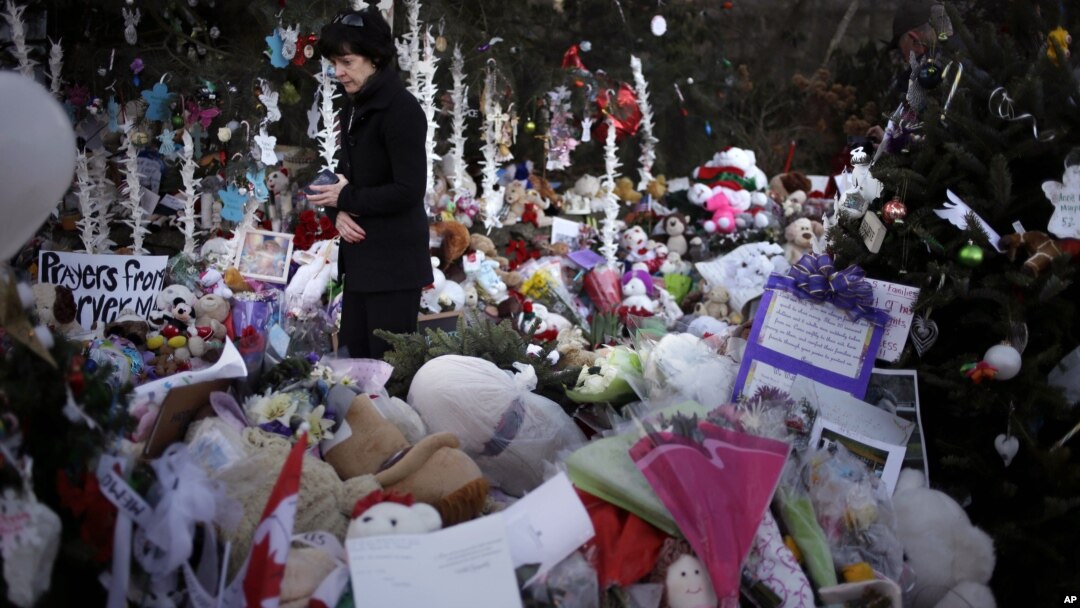 Jeanne Walker walks through an overflowing memorial to the shooting victims, Newtown, Connecticut, December 20, 2012. 