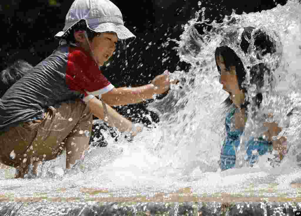 Anak-anak Jepang bermain air mancur di taman 'Asuka' di Tokyo.