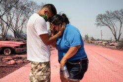 Dora Negrete es consolada por su hijo Hector Rocha después que su vivienda en el parque de casas rodantes Talent Mobile Estates, se quemara en un incendio forestal el jueves 10 de septiembre de 2020, en Talent, Oregón.