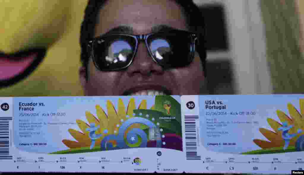 Anderson, seorang penggemar sepak bola Brasil berpose di depan media setelah mengambil tiket Piala Dunia 2014 miliknya di Rio de Janeiro. Pusat-pusat penjualan tiket FIFA dibuka di kota-kota negara tuan rumah Piala Dunia. 
