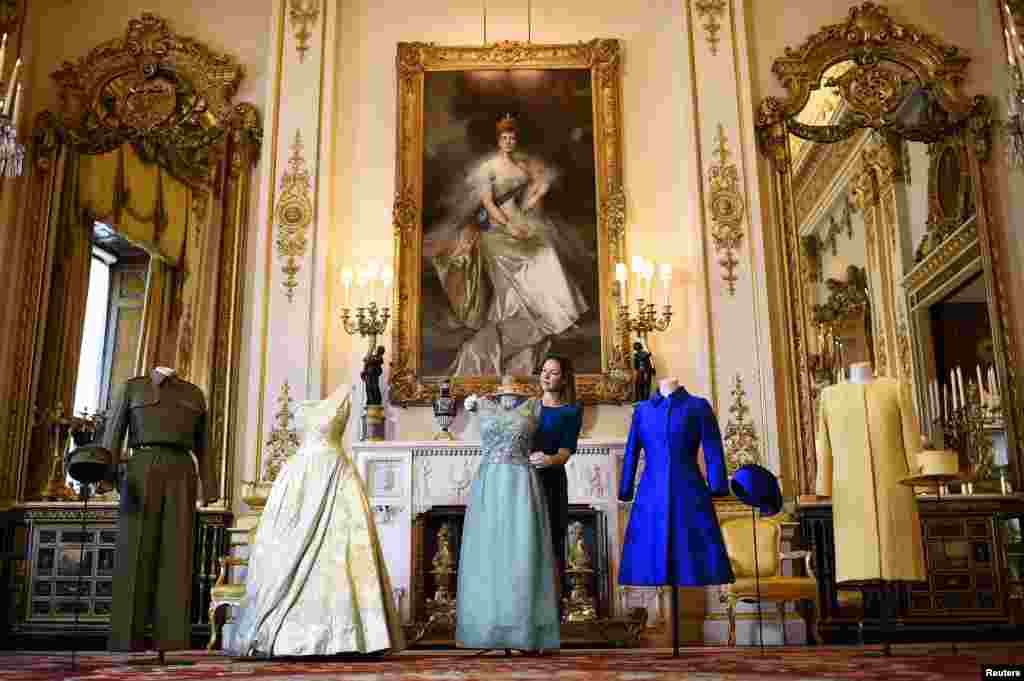 Curator Caroline de Guitaut shows off a preview of an exhibition entitled 'Fashioning a Reign: 90 Years of Style from The Queen's Wardrobe,' charting the reign of Britain's Queen Elizabeth via a display of her formal and informal outfits, at Buckingham Palace, in central London.