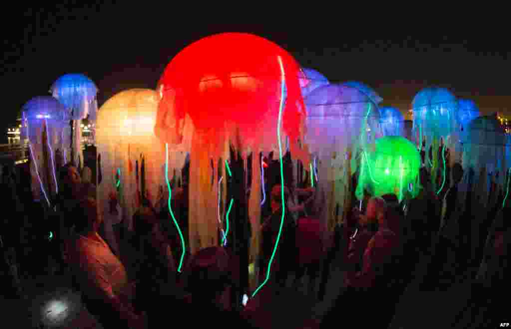 Visitors explore Swarm of interactive jellyfish created by the group of artists Aphidoidea during Glow 2013 at the beach in Santa Monica, California, Sept. 29, 2013.
