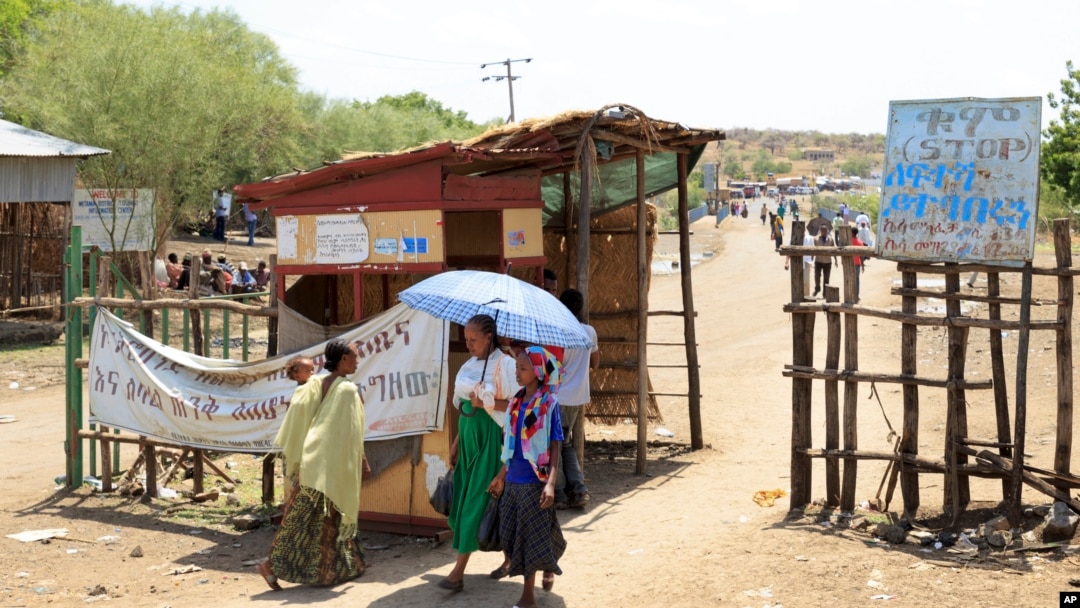 FILE - People walk past a checkpoint in northwestern Ethiopia next to the border with Sudan, June 3, 2015. Sudan and Ethiopia agreed Tuesday to deploy joint forces to secure their border. 