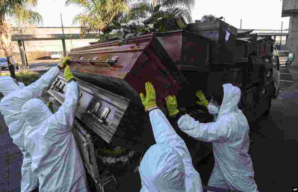 Workers collect and stack the coffins of people who have been recently cremated, at La Recoleta cemetery, amid the new coronavirus pandemic in Santiago, Chile, June 30, 2020. The coffins are destroyed by a company specializing in organic waste. 