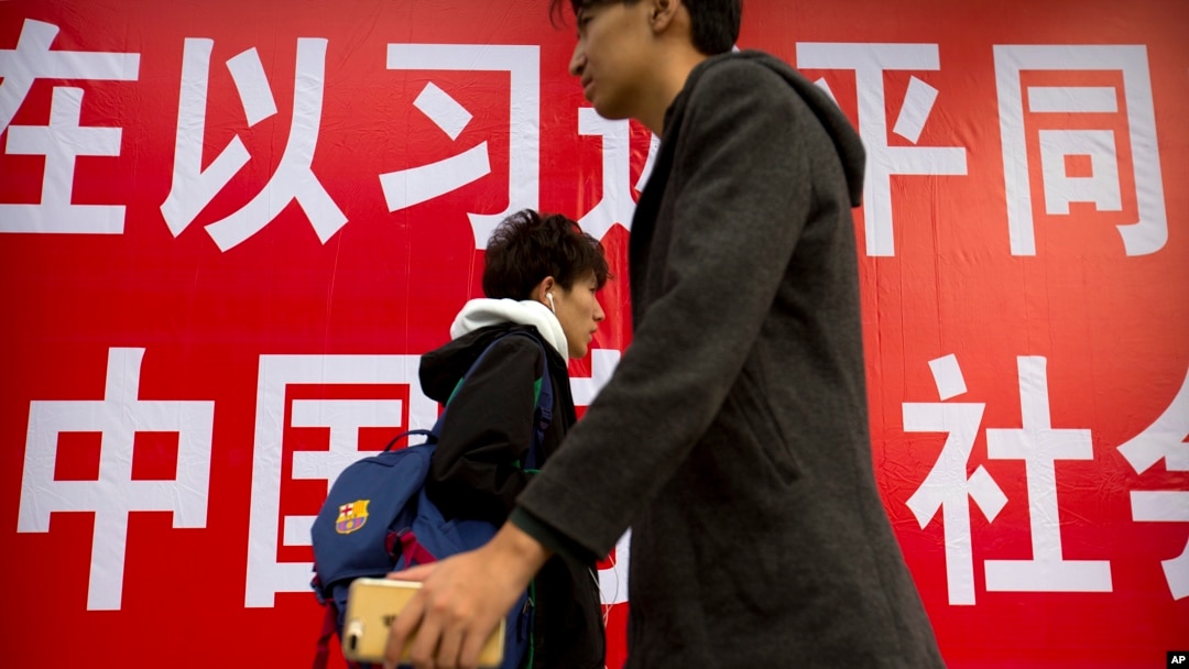 北京街頭的行人走過宣傳習近平的標語。